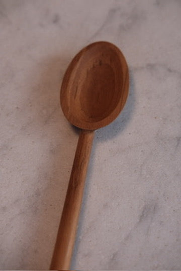 Rød ske i teaktræ, 20 cm, køkkenredskab fra Kunst og Køkkentøj, vises med naturlig trætekstur og håndtag.