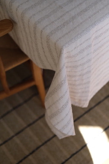 Hørdug fra Linge Particulier, broderet i taupe, måler 140 x 250 cm, med fint vævet mønster og elegant design.