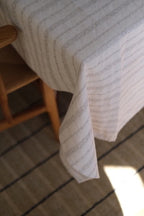 Hørdug fra Linge Particulier, broderet i taupe, måler 140 x 250 cm, med fint vævet mønster og elegant design.