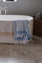Blue DORA hand towel measuring 140x70 cm, folded with soft fabric visible and textured surface.