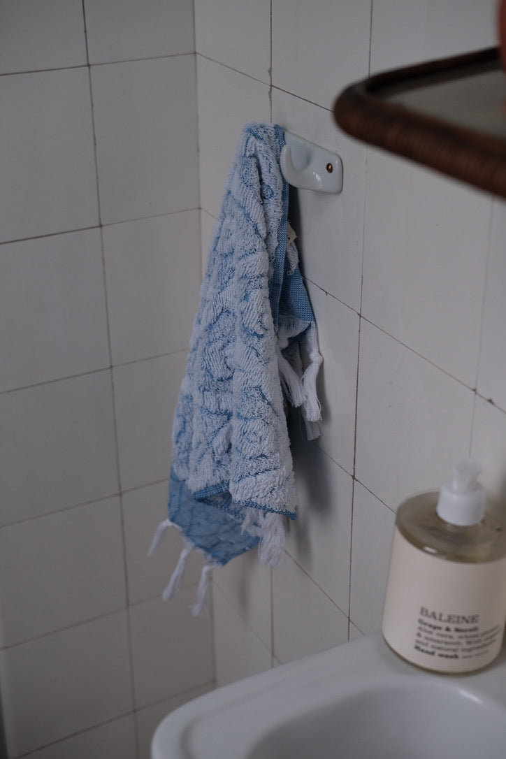 Blue DORA hand towel measuring 50x30 cm, soft and absorbent, displayed on a neutral background.