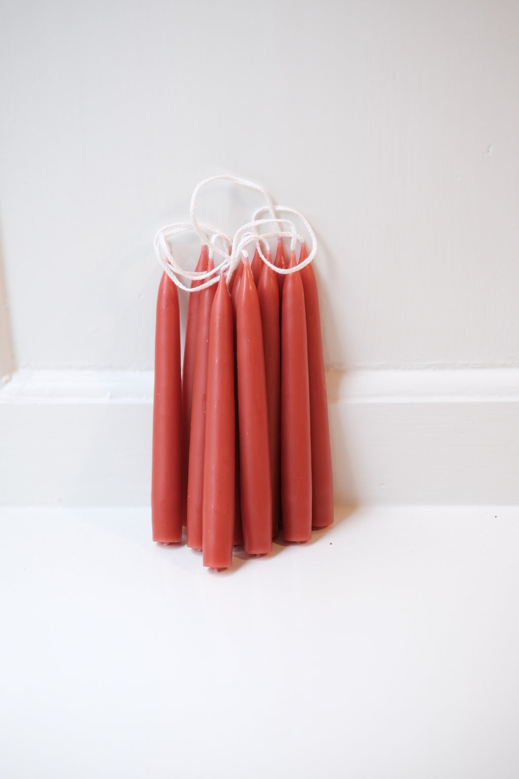 Rust-colored hand-dipped stearin candle from Kunstindustrien, 12 cm tall, with a textured, handcrafted appearance.