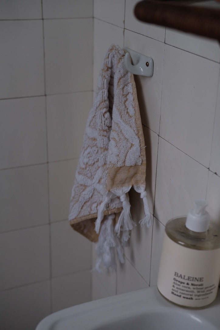 Yellow DORA hand towel, 50x30 cm, made of soft fabric, displayed folded on a white background.