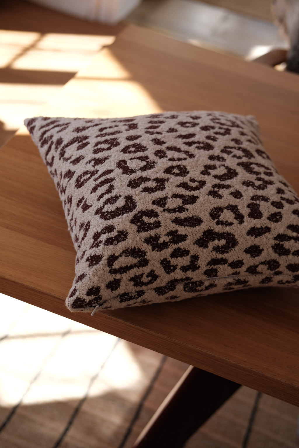 Hvid og bordeaux leopard uldpude fra DORA, mellemstørrelse med eksklusivt mønster og blødt uldmateriale.