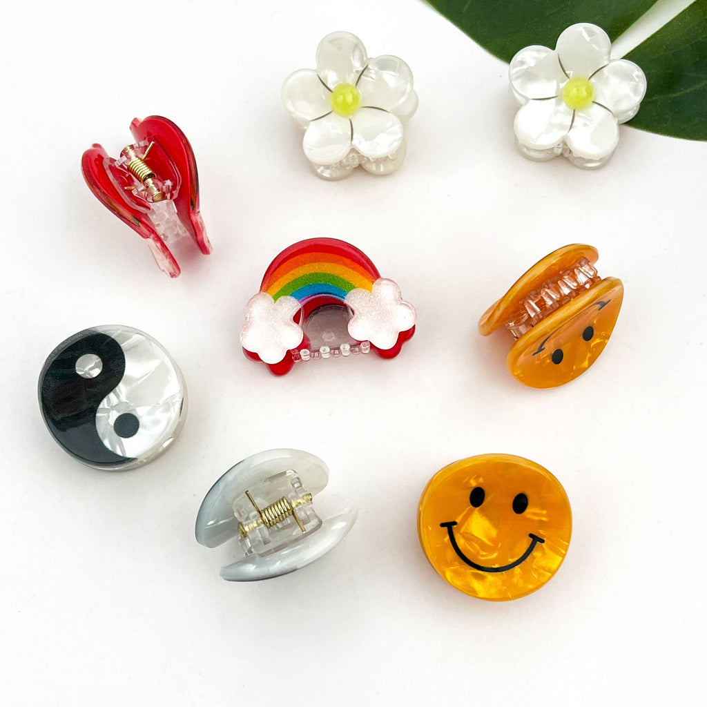 DORA mini hårklemme med smiley-design, perfekt til at style håret med sjov og farverig detalje.