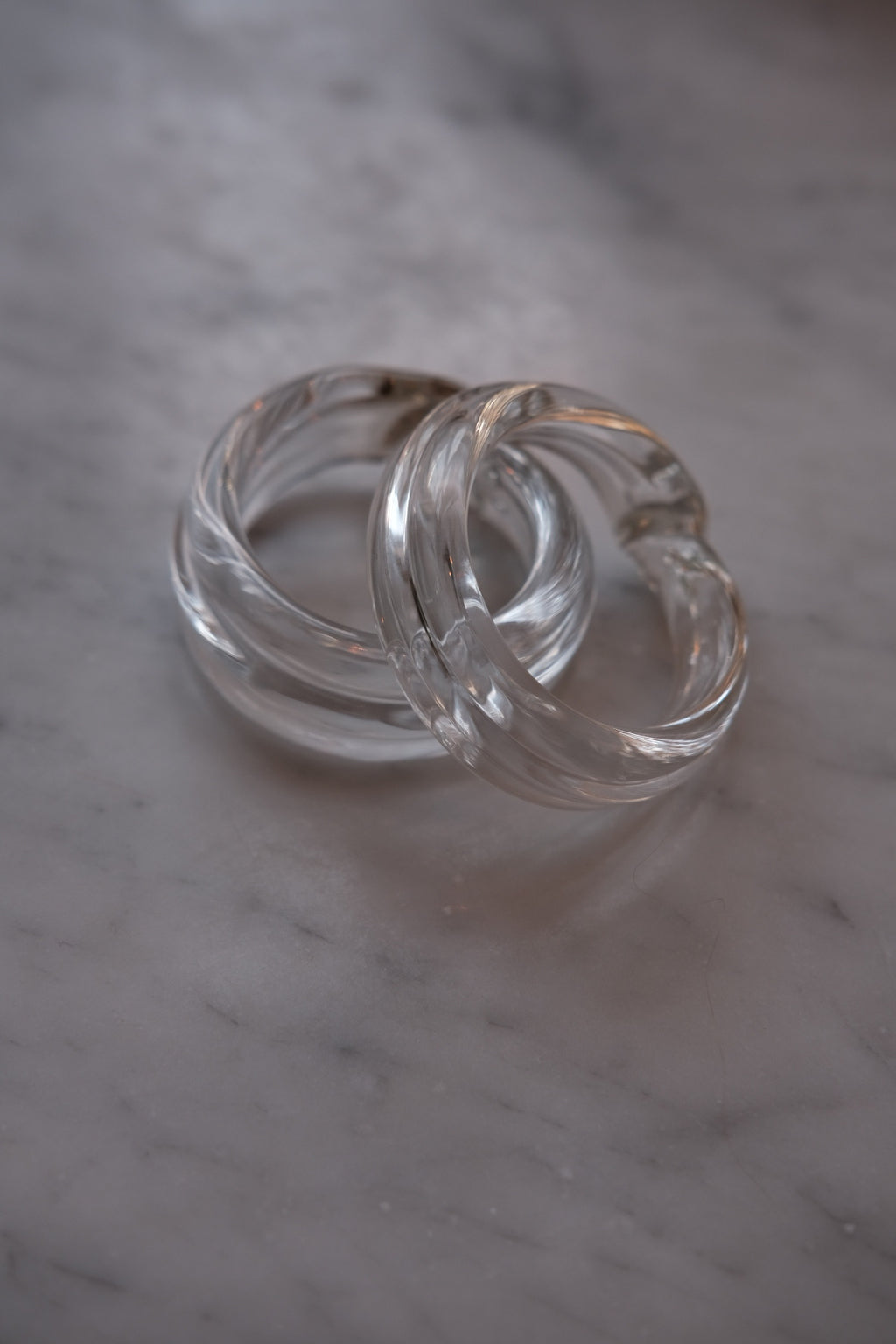Set of two Marqversen Möglich glass napkin rings with clear, hand-blown design and circular shape.