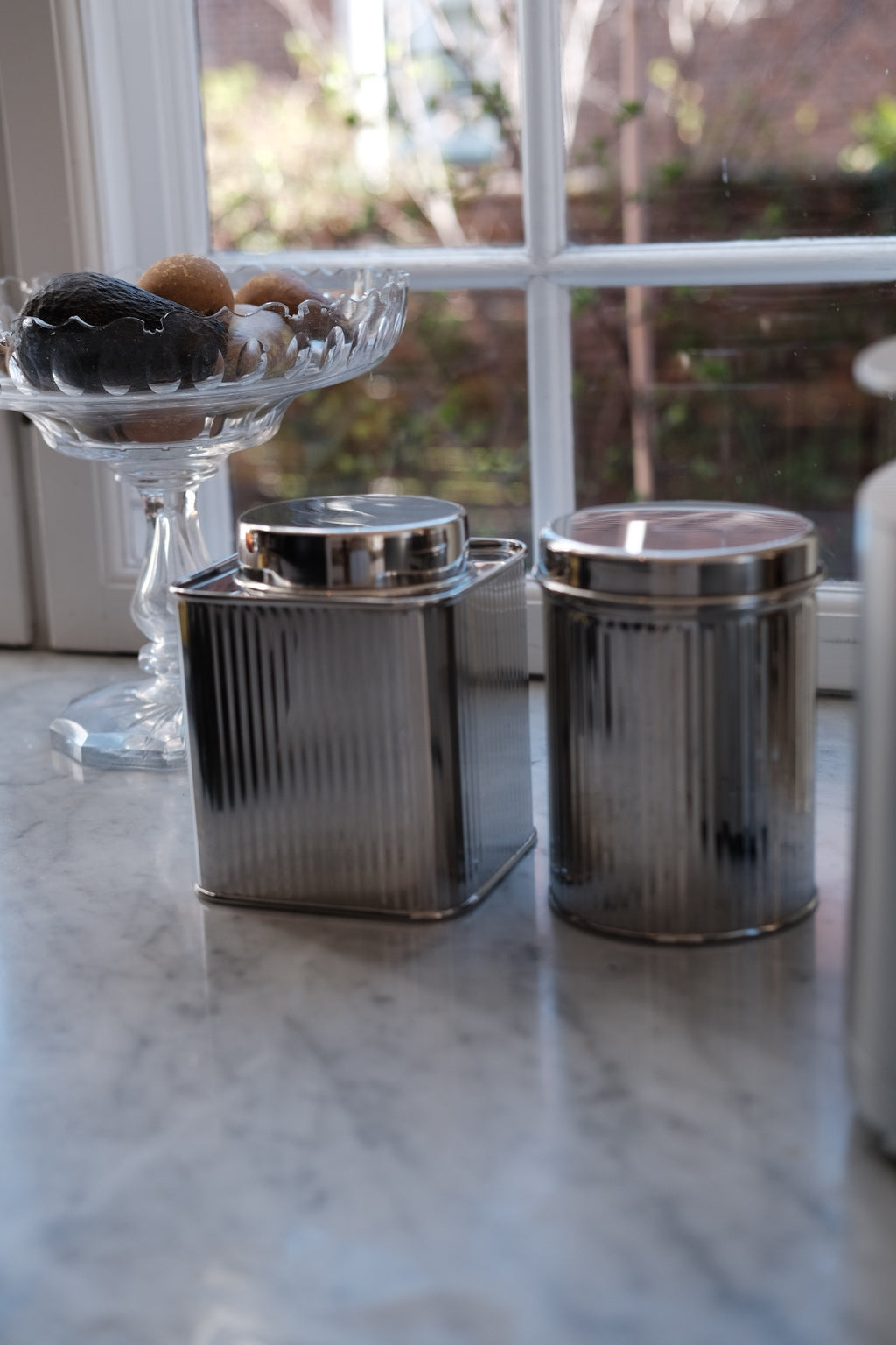 Firkantet stål dåse fra Bungalow, moderne opbevaringsbeholder med metalfinish, synlig i billedet.