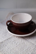 Brun kop og underkop fra ACME Classic Medium, keramisk kaffekop med matchende underkop, elegant og funktionel.