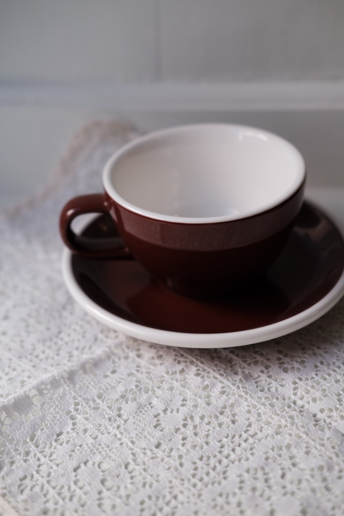 Brun kop og underkop fra ACME Classic Medium, keramisk kaffekop med matchende underkop, elegant og funktionel.