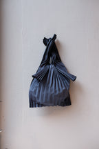 Mini mørkeblå plisseret taske fra Pleco, biologisk nedbrydelig og miljøvenlig, med elegant design.
