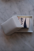 Lille smørskål i porcelæn fra DORA med glat hvid overflade til smørservering.