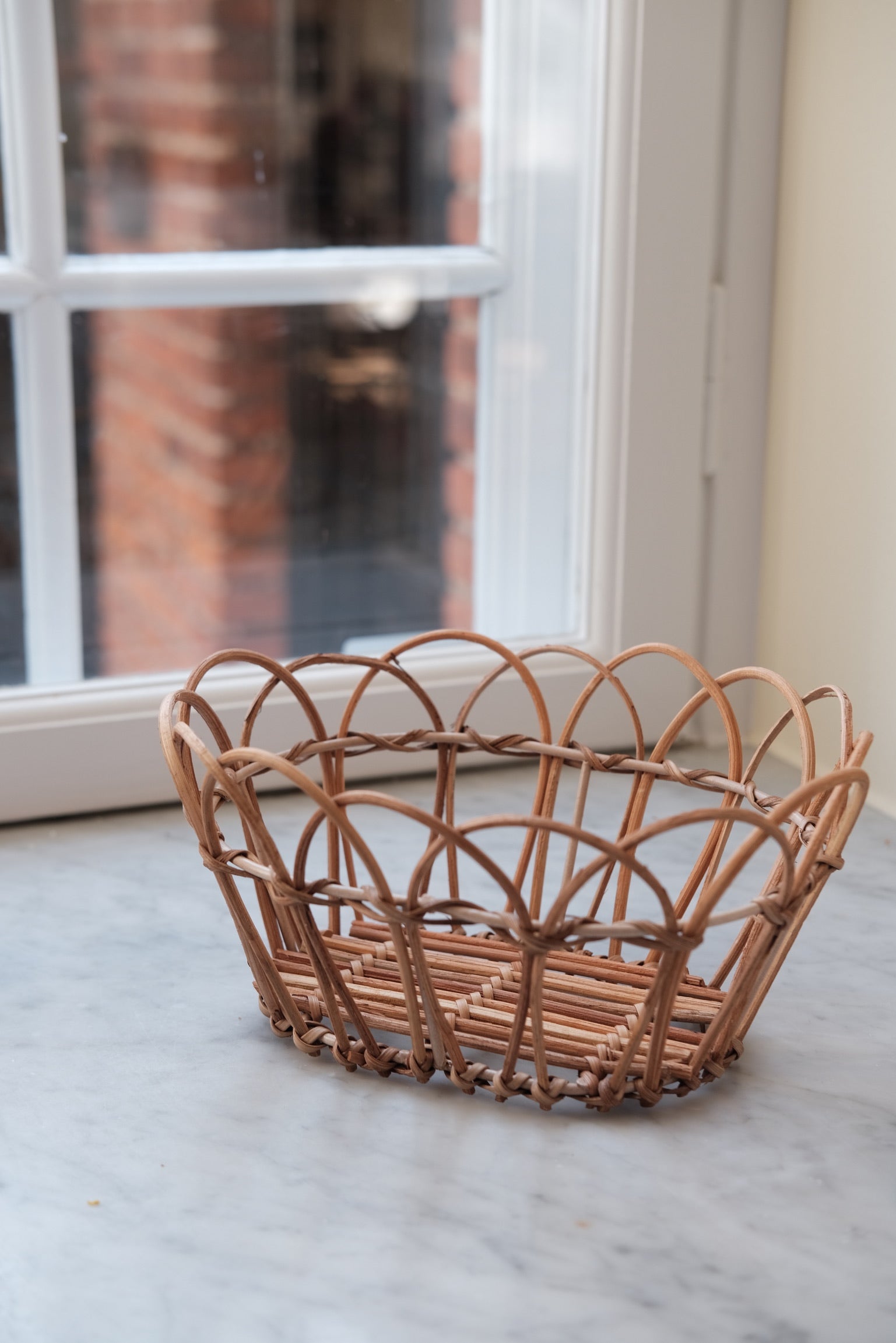 Small rattan bread basket by Bungalow, featuring a woven design perfect for serving or storing bread.