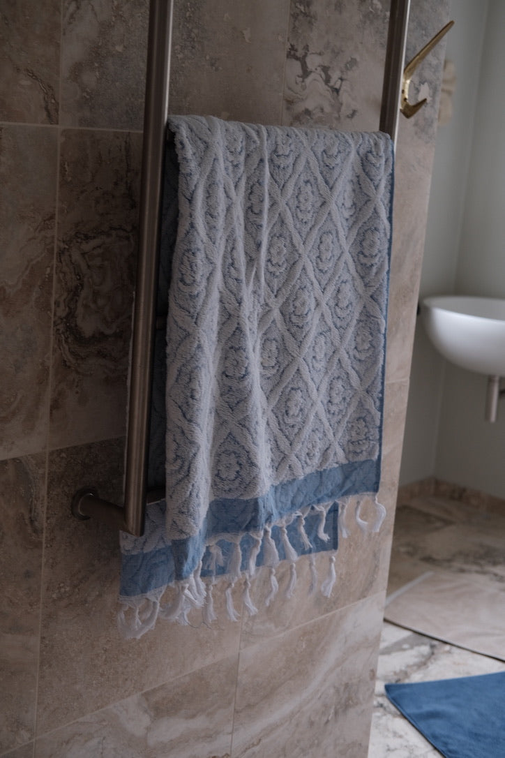 Blue DORA hand towel, 140x70 cm, soft cotton fabric with a smooth texture and neatly hemmed edges.
