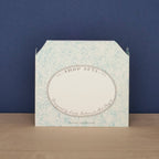 Art Angels Kort featuring a vibrant green grocer illustration with fresh produce and a charming market scene.