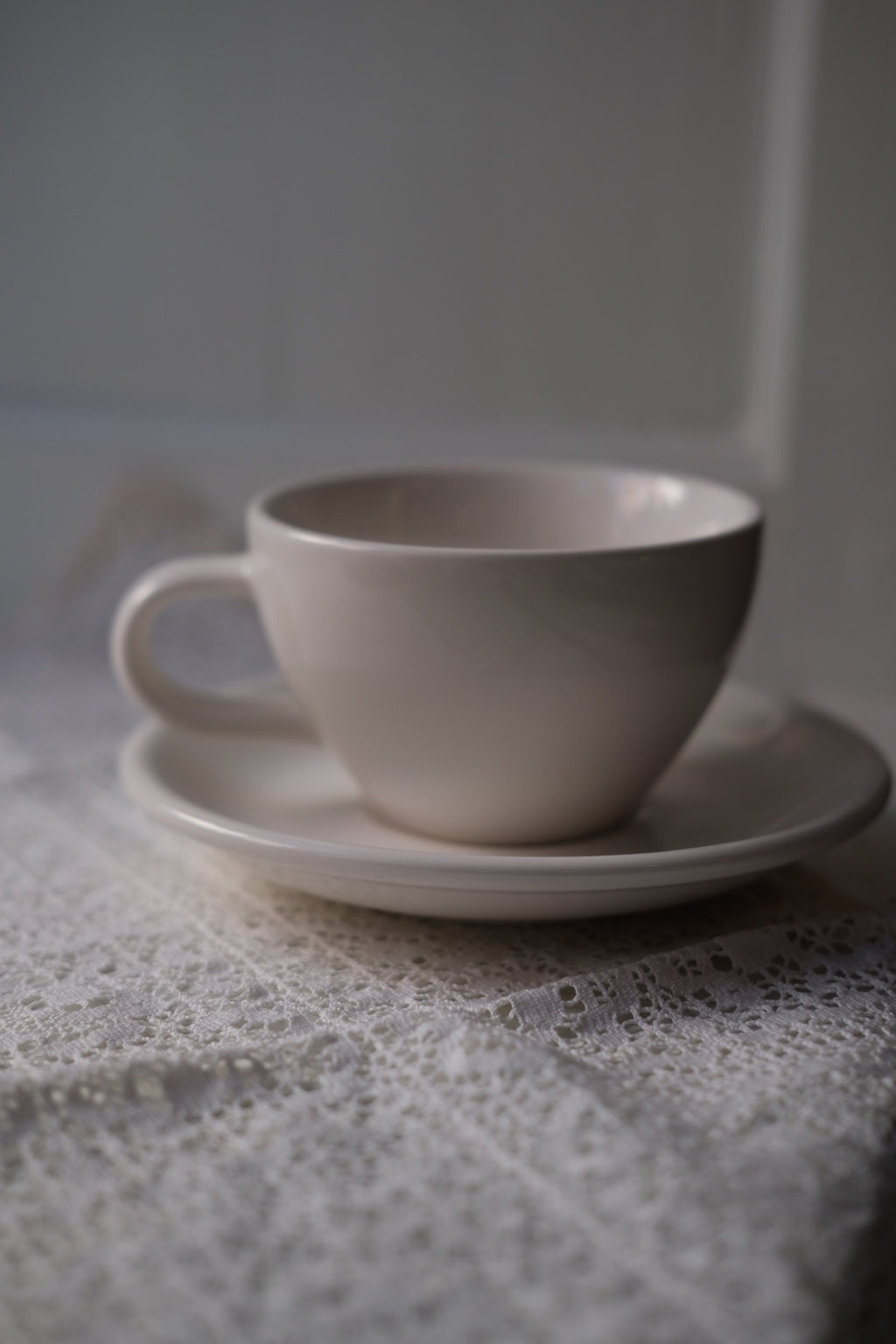 Hvid kop og underkop fra ACME Classic Medium, keramisk kop med matchende underkop, elegant og funktionel kaffekop.