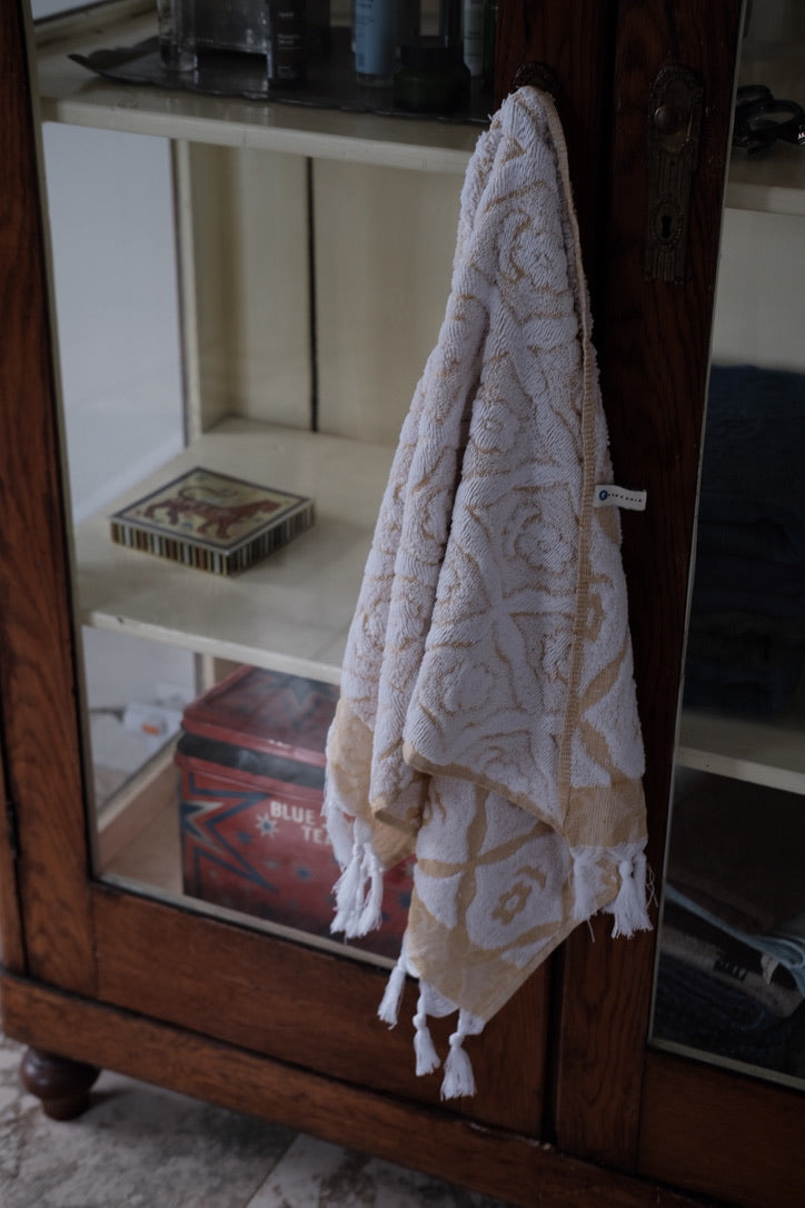 Bright yellow DORA hand towel measuring 100x50 cm, made of soft, absorbent fabric, displayed flat on a white background.