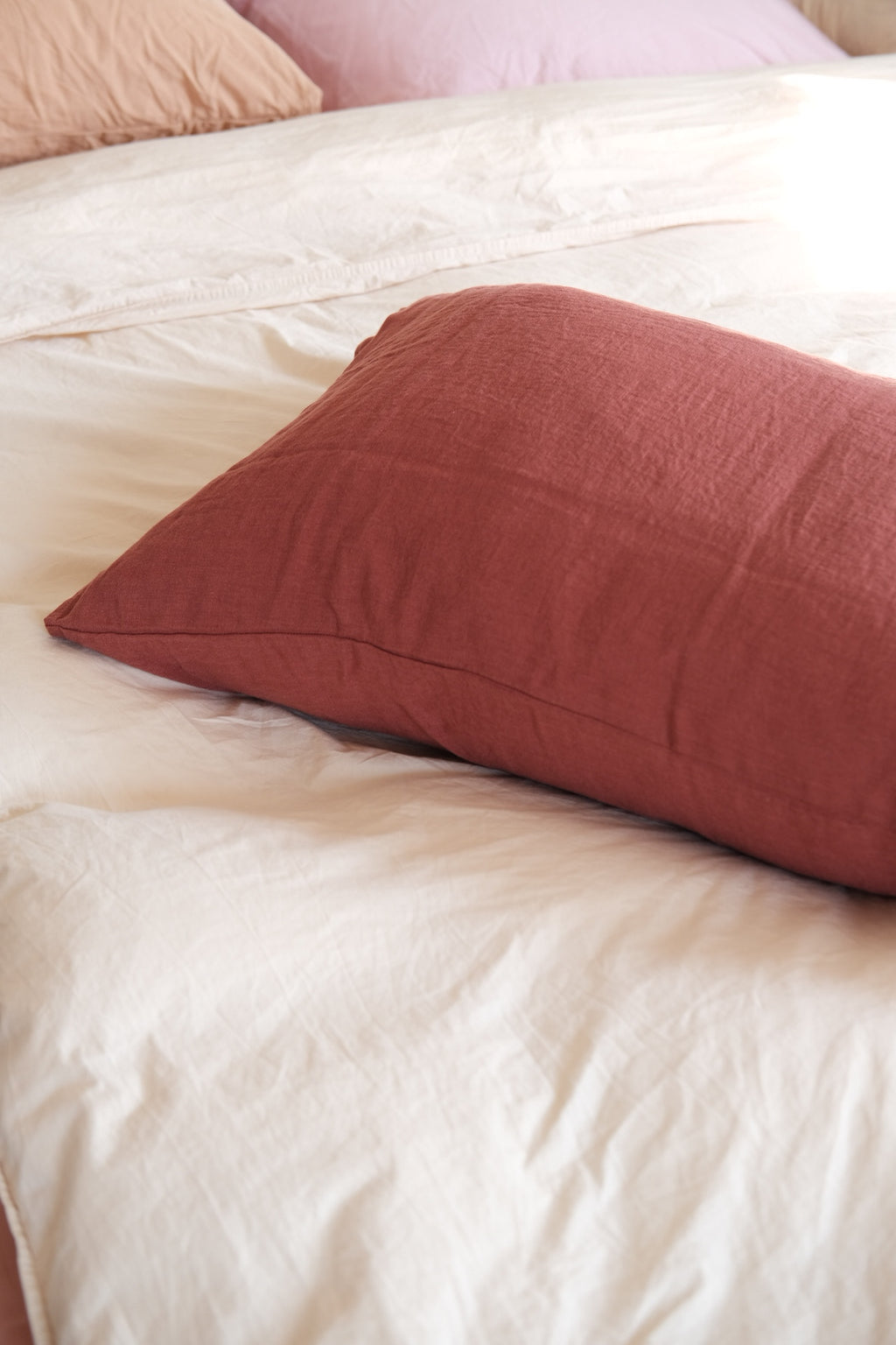 Linge Particulier Pudevår linen pillow in Brique color, 50x70 cm, showing textured fabric and decorative pillow design.