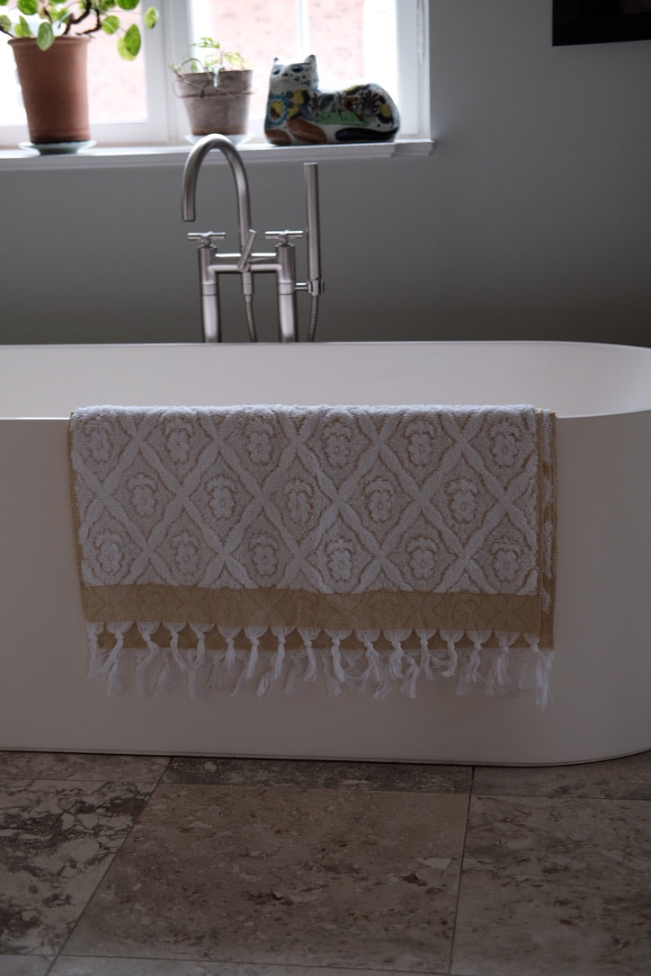 Yellow DORA hand towel measuring 140x70 cm, soft fabric with a smooth texture, displayed flat on a neutral background.