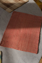Guanabana Iraca dækkeserviet with red and natural palm leaf design, showcasing intricate palmblade patterns on woven material.