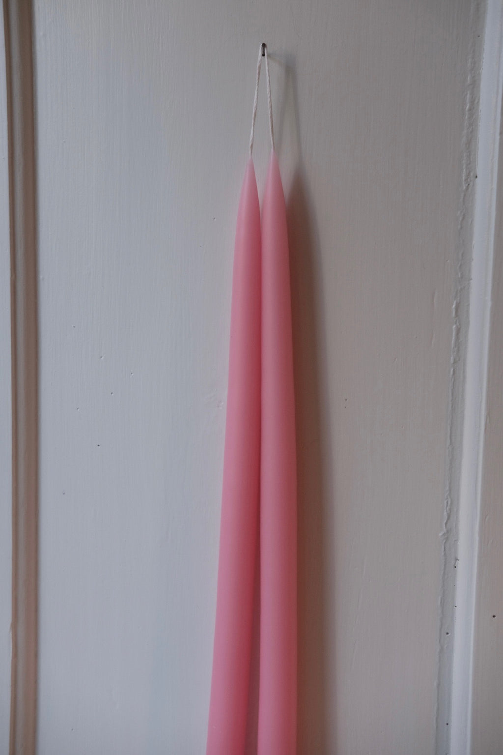 Hand-dipped Kronelys stearinlys in baby pink, 45 cm tall, by Kunstindustrien, shown in a natural candle display.