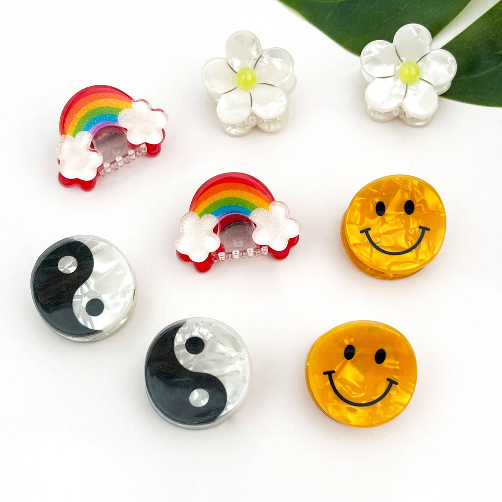 DORA mini hårlås med smilende smiley-motiv, lille hårklemme til børn eller tilbehør, synlig i billedet