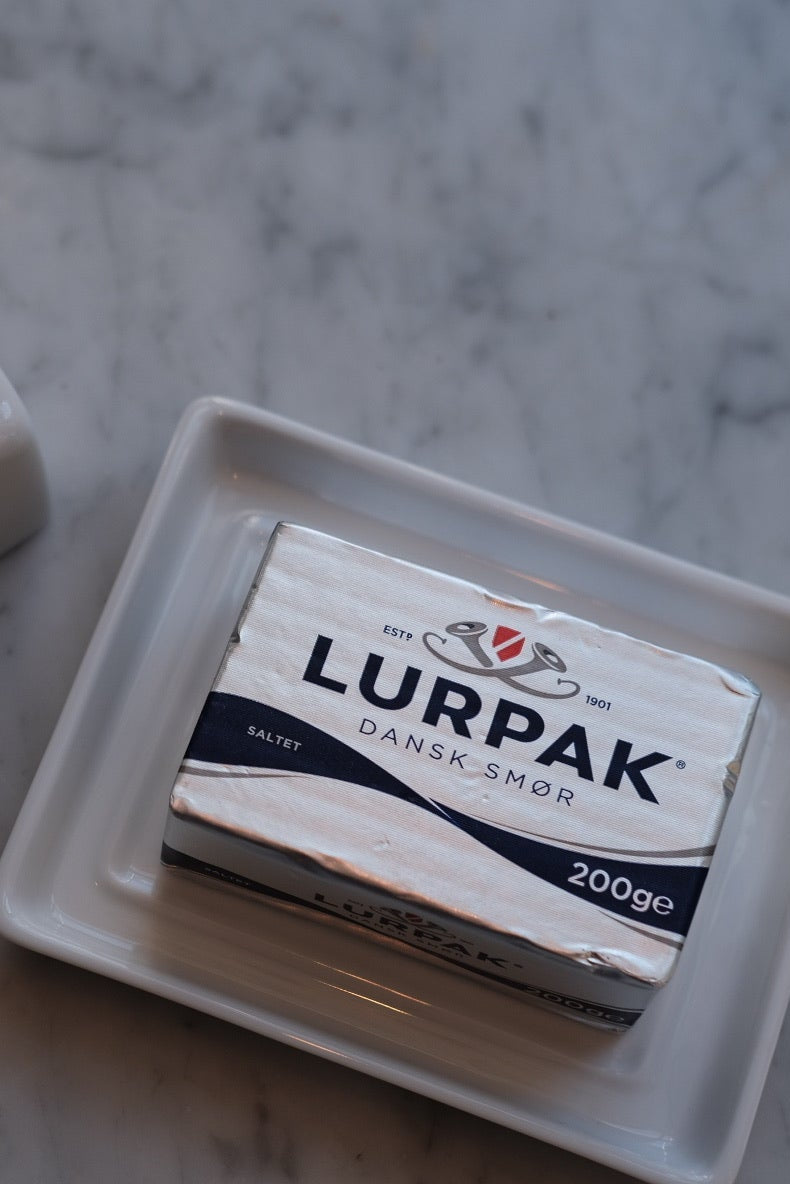 Stor smørskål i porcelæn fra DORA med glat overflade og rund form, perfekt til servering af smør.