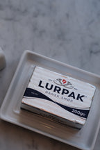 Stor smørskål i porcelæn fra DORA med glat overflade og rund form, perfekt til servering af smør.