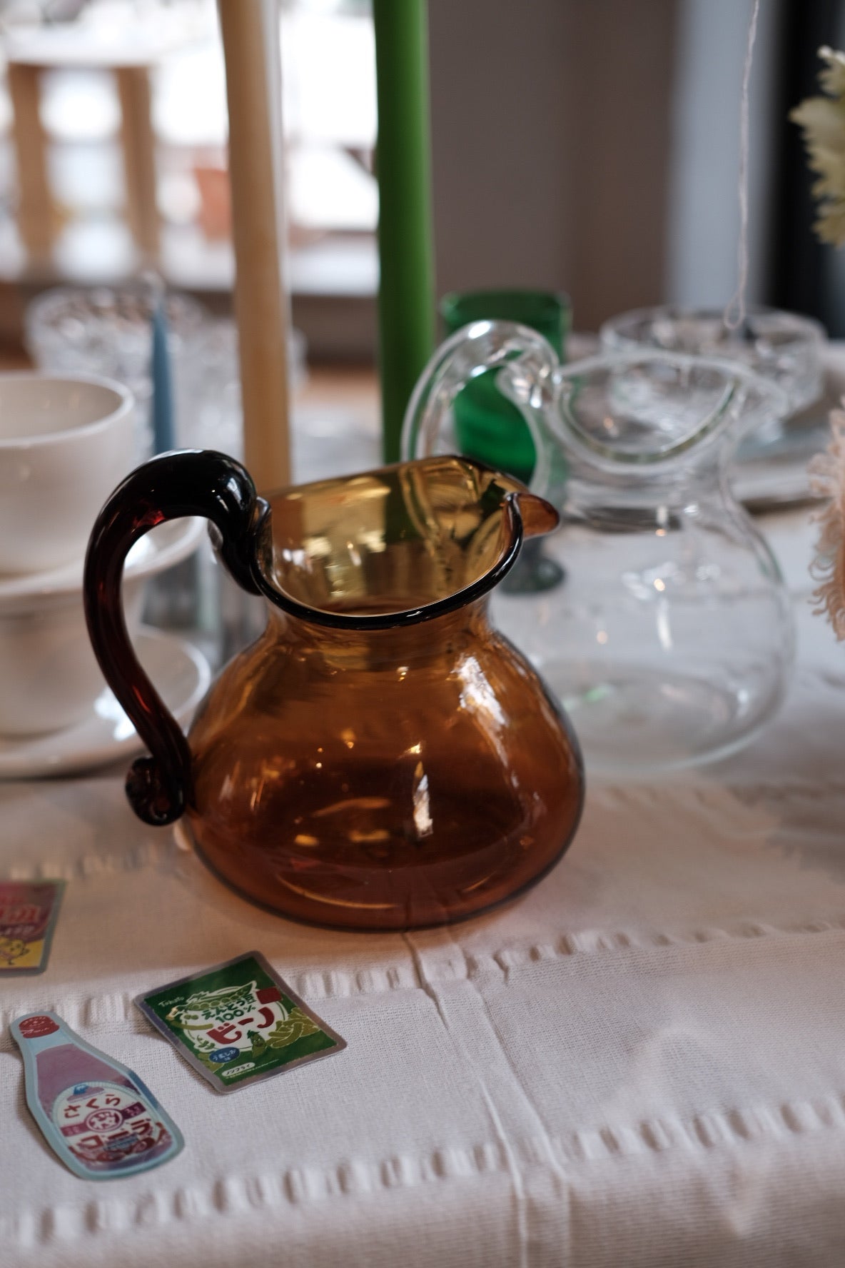 Mundblæst Murano-glaskande fra Akua Objects med elegant form og klart glas, perfekt til servering af væsker.