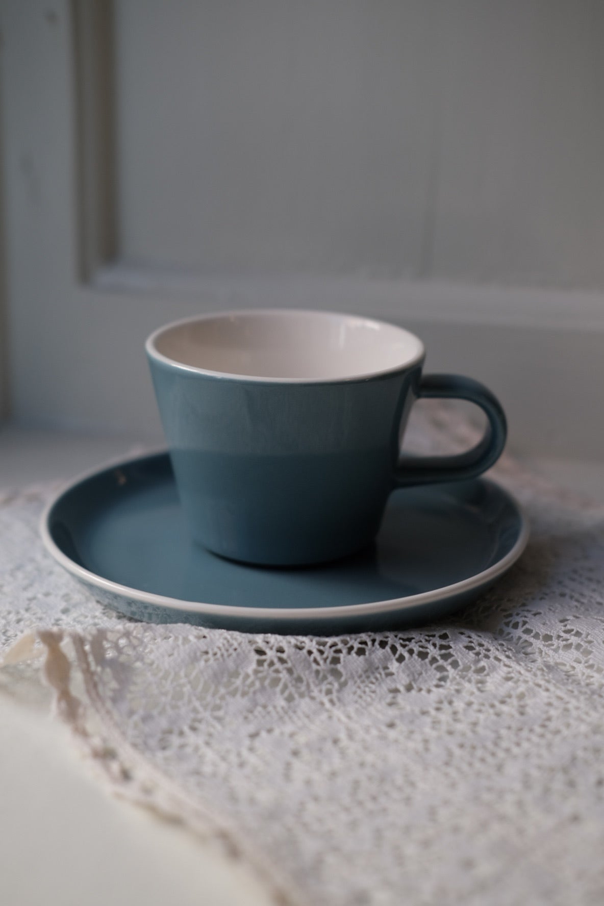 Blå kop og underkop fra Acme Roman Kōkako serie, elegant keramik design i dyb blå nuance, stemplet med ACME mærke