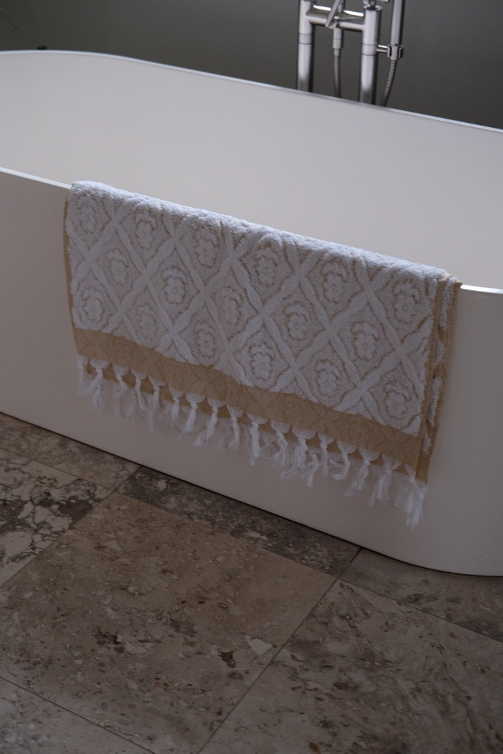 Yellow DORA hand towel, 140x70 cm, soft and absorbent, displayed folded on a neutral background.