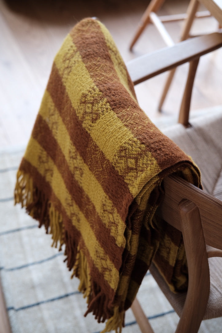 Tweedmill orange and terracotta plaid blanket with a classic tartan pattern, made from soft woven tweed fabric.