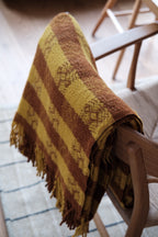 Tweedmill orange and terracotta plaid blanket with a classic tartan pattern, made from soft woven tweed fabric.