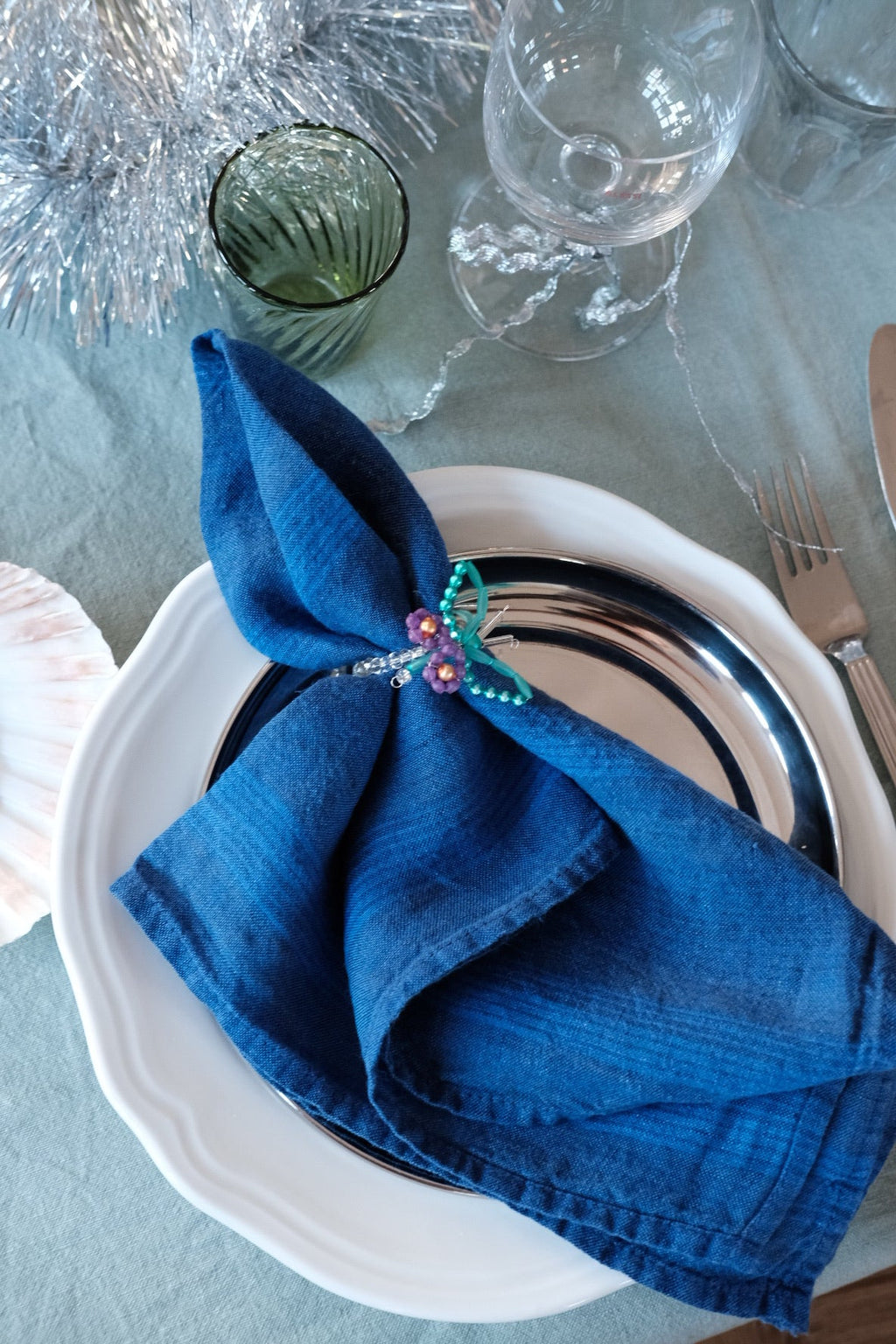 Hørserviet fra Linge Particulier i Rayure Indigo med blå og hvide striber, elegant tekstil til borddækning.
