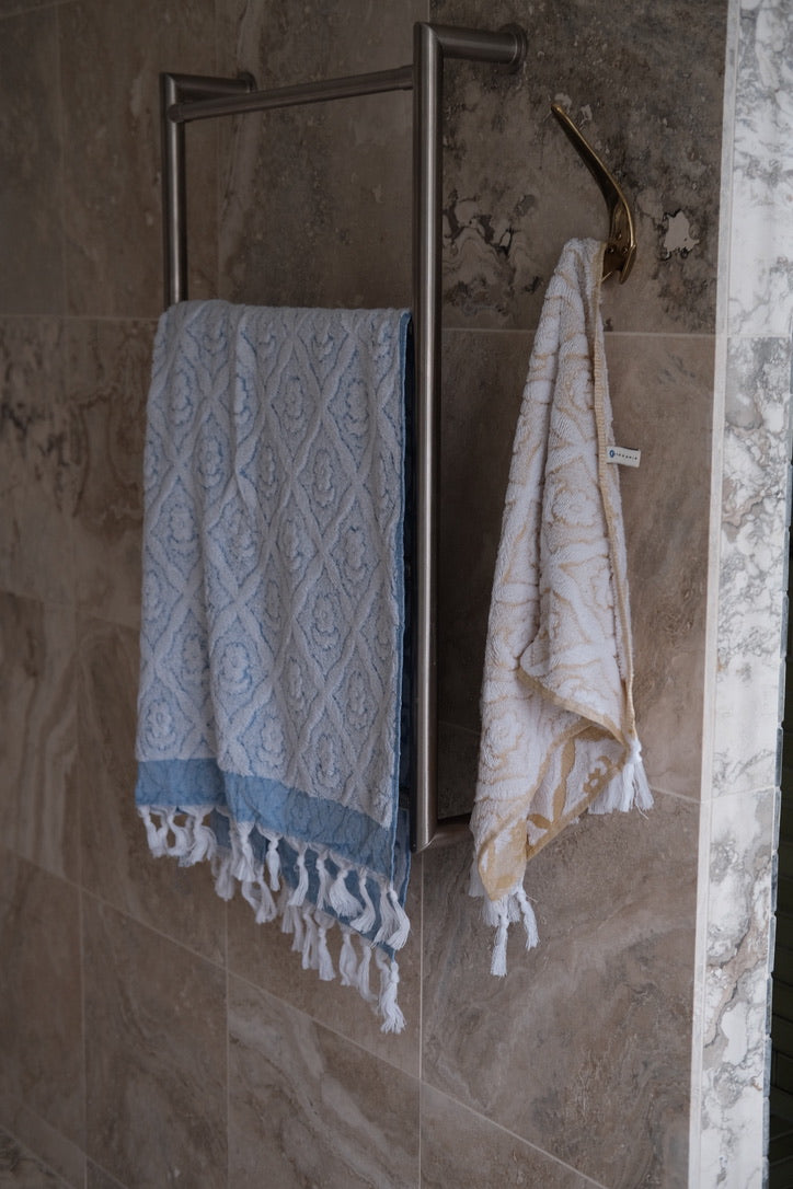 Blue DORA hand towel measuring 140x70 cm, soft and absorbent, displayed folded with textured fabric visible.