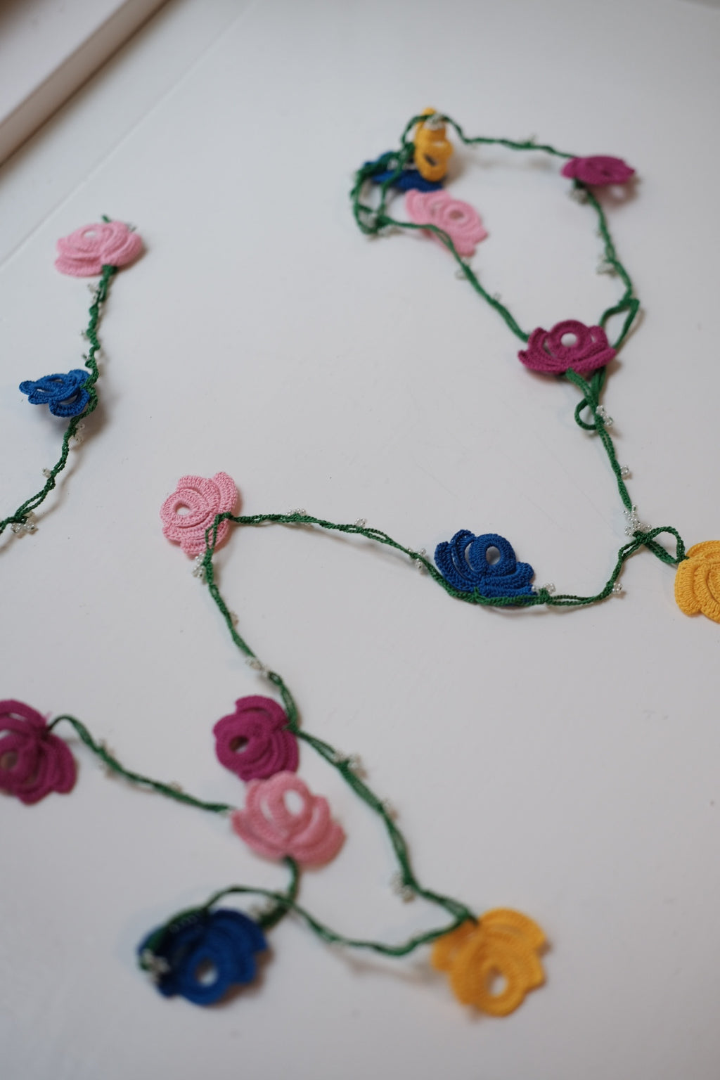 Grøn guirlande med blomsterdesign fra Østerland, perfekt til dekoration og festligheder.