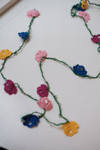 Green flower garland by Østerland, featuring vibrant blooms and a delicate design for festive decor.