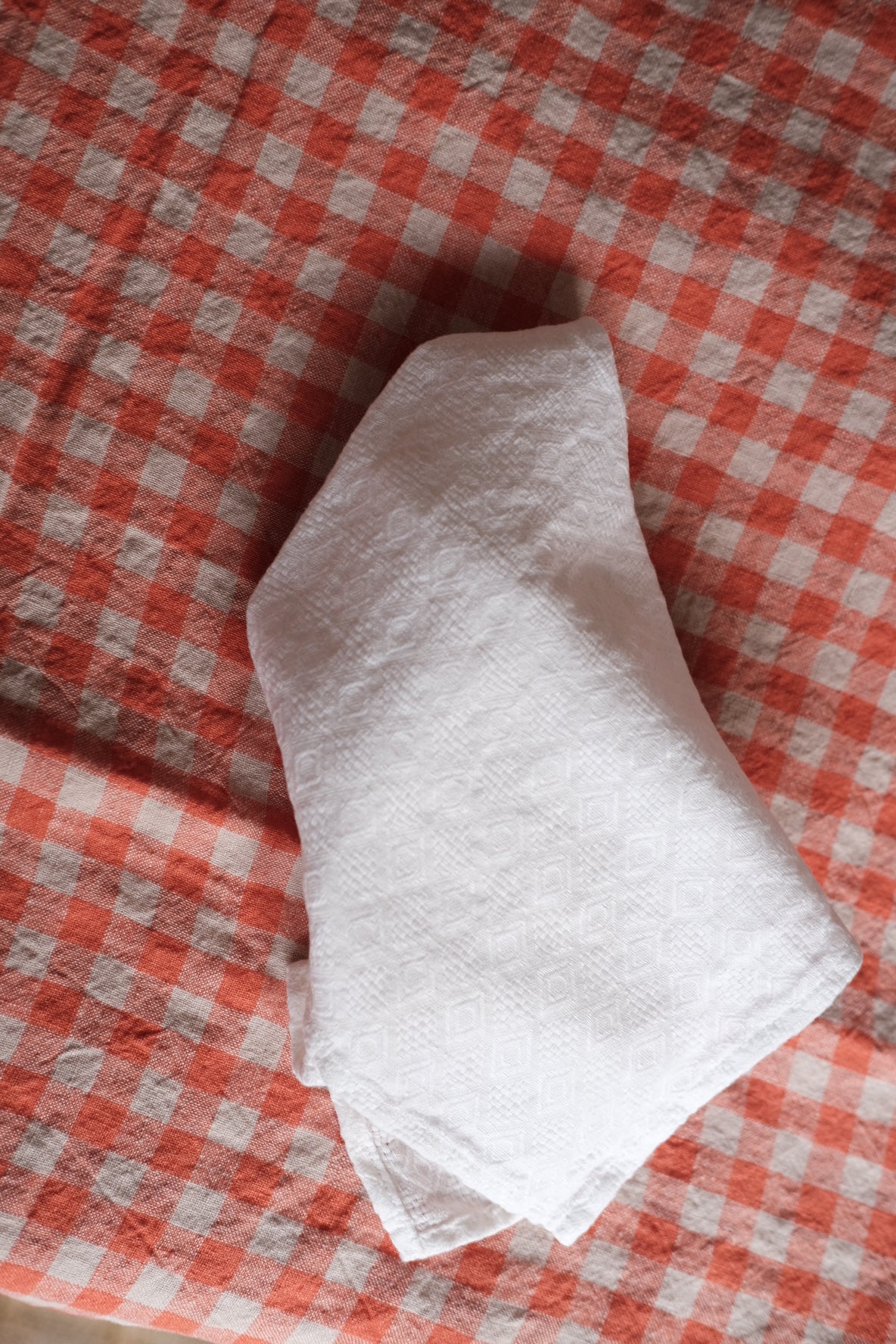 White linen embroidered napkin with elegant stitching, showcasing a high-quality fabric and detailed craftsmanship.