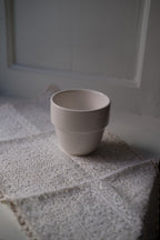 Hvid kop fra ACME Taster serien, mælkehvid med enkel design og rund form, perfekt til kaffe eller te.