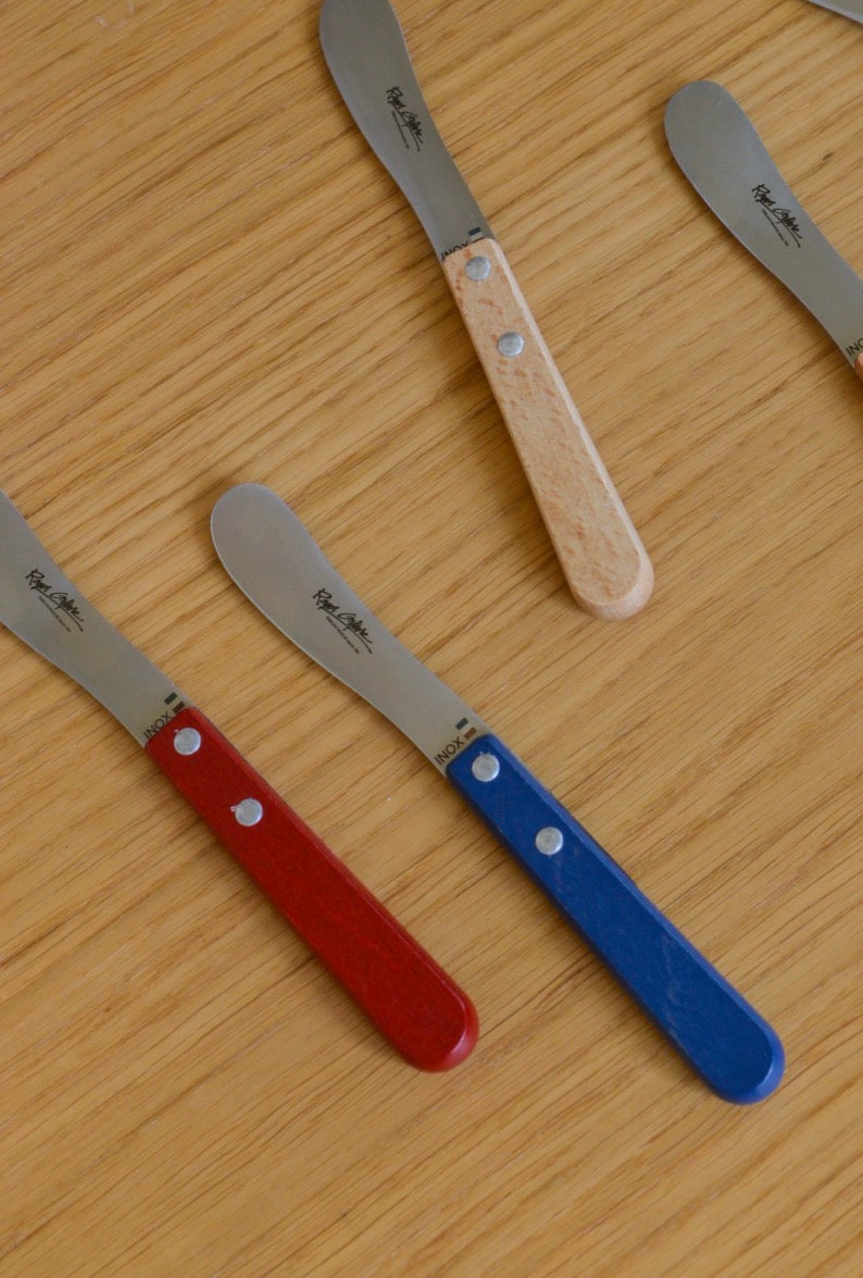 Blue Roger Orfevre butter knife with a wooden handle, featuring a sleek and ergonomic design for spreading butter.