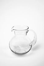 Kira kande i klart glas med rund form og buet hank