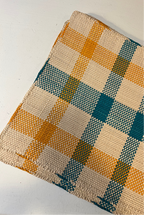 Guanabana Iraca cloth placemat with orange and blue checkered palm leaf design on natural fibers.