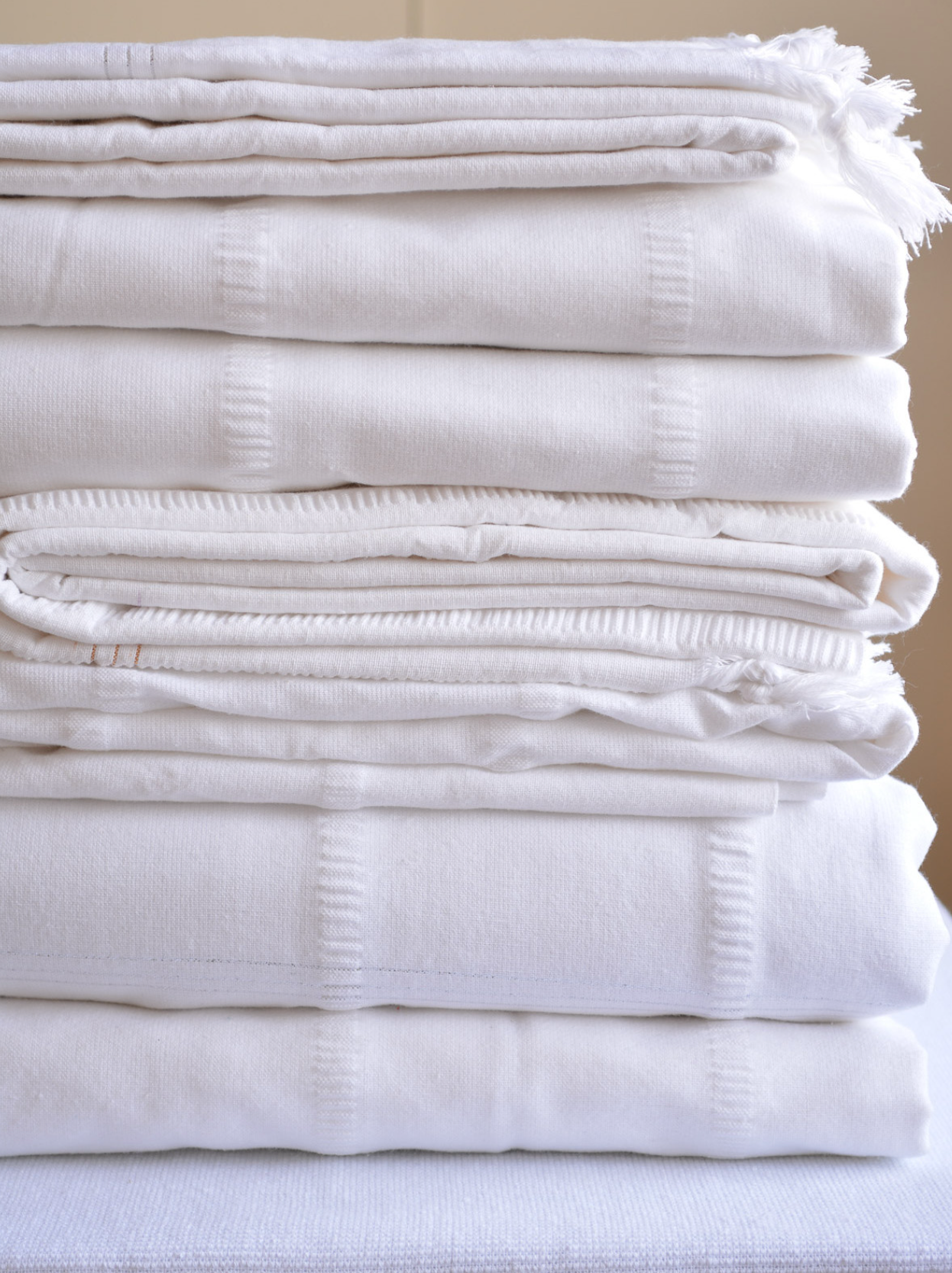 White DORA cotton hand towel, 180 x 350 cm, displayed flat on a surface with soft fabric texture.