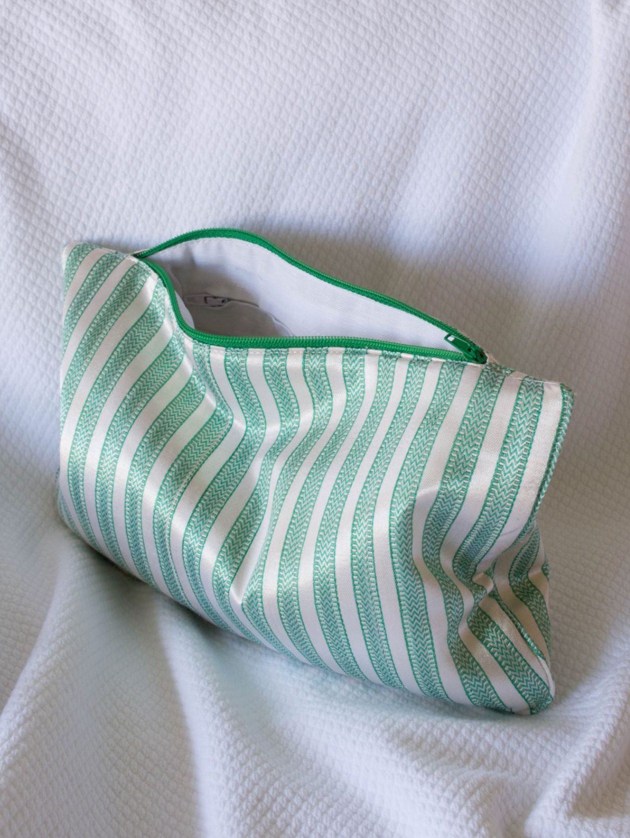 Light green and cream DORA toilettaske in medium size, with a sleek design and compact shape for travel essentials.