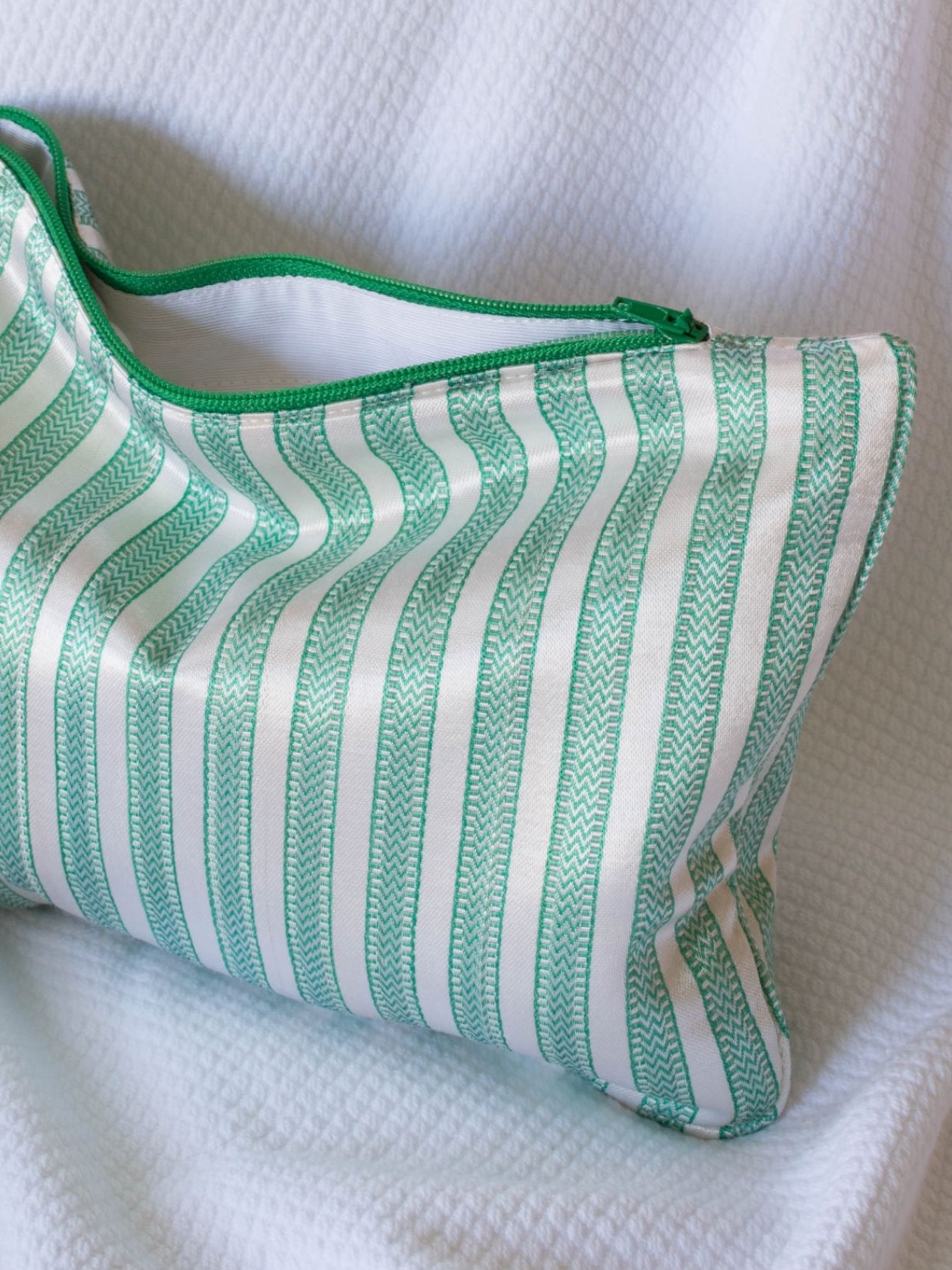 Light green and cream medium DORA toilettaske with a sleek, compact design ideal for travel and personal care storage.