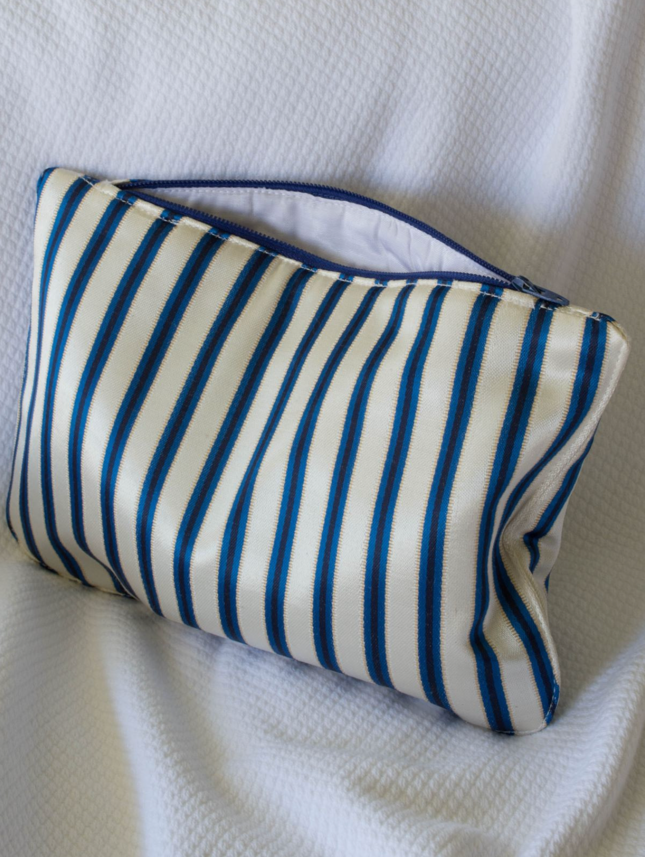 Blue and cream medium DORA toilettaske with zipper closure, compact and stylish for travel storage.