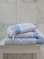 Blue DORA hand towel measuring 100x50 cm, displayed folded with soft textured fabric and subtle woven pattern.