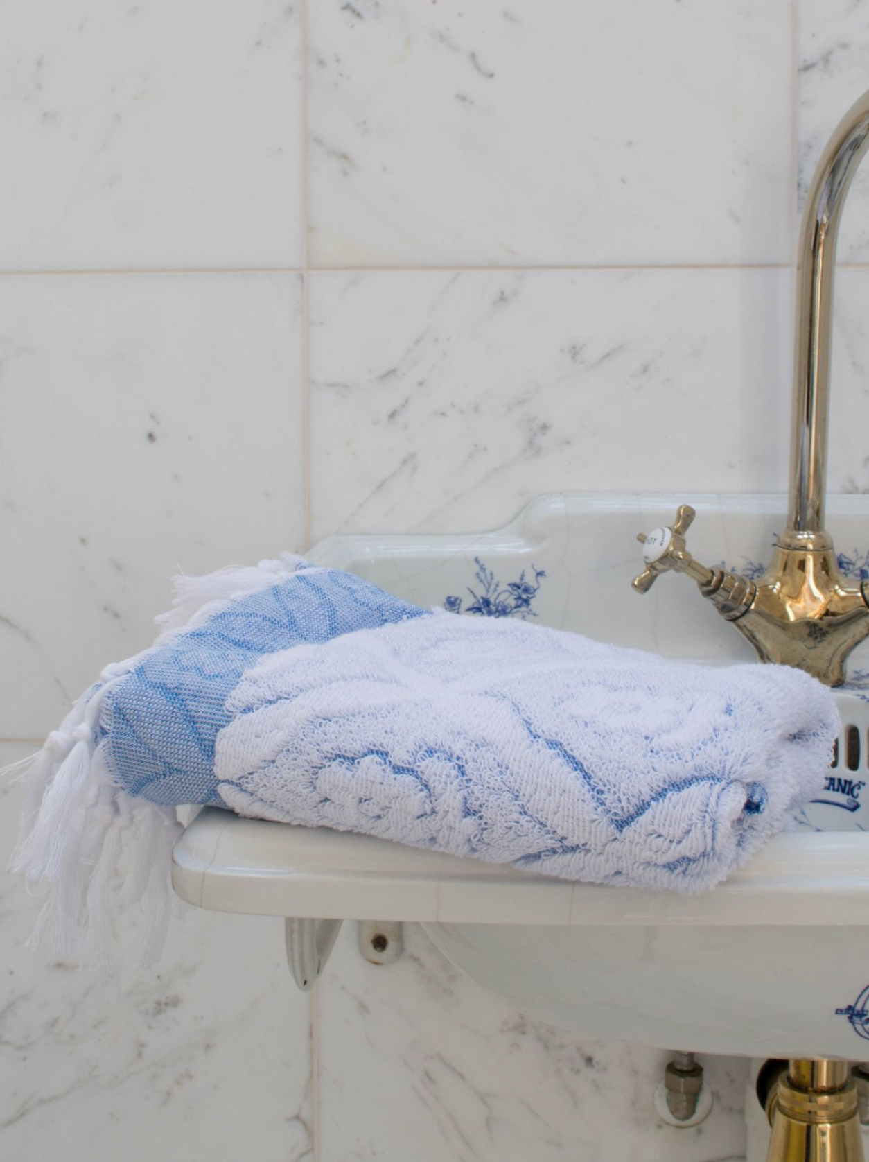 Blue DORA hand towel measuring 100x50 cm, soft and absorbent, displayed flat with textured fabric visible