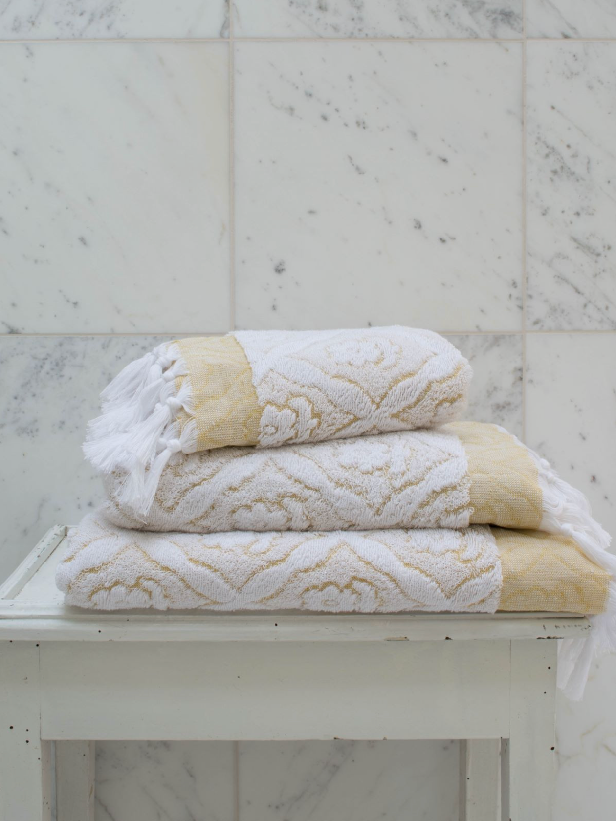 Yellow DORA hand towel, 50x30 cm, showing soft fabric with stitched edges, ideal for bathroom or kitchen use.