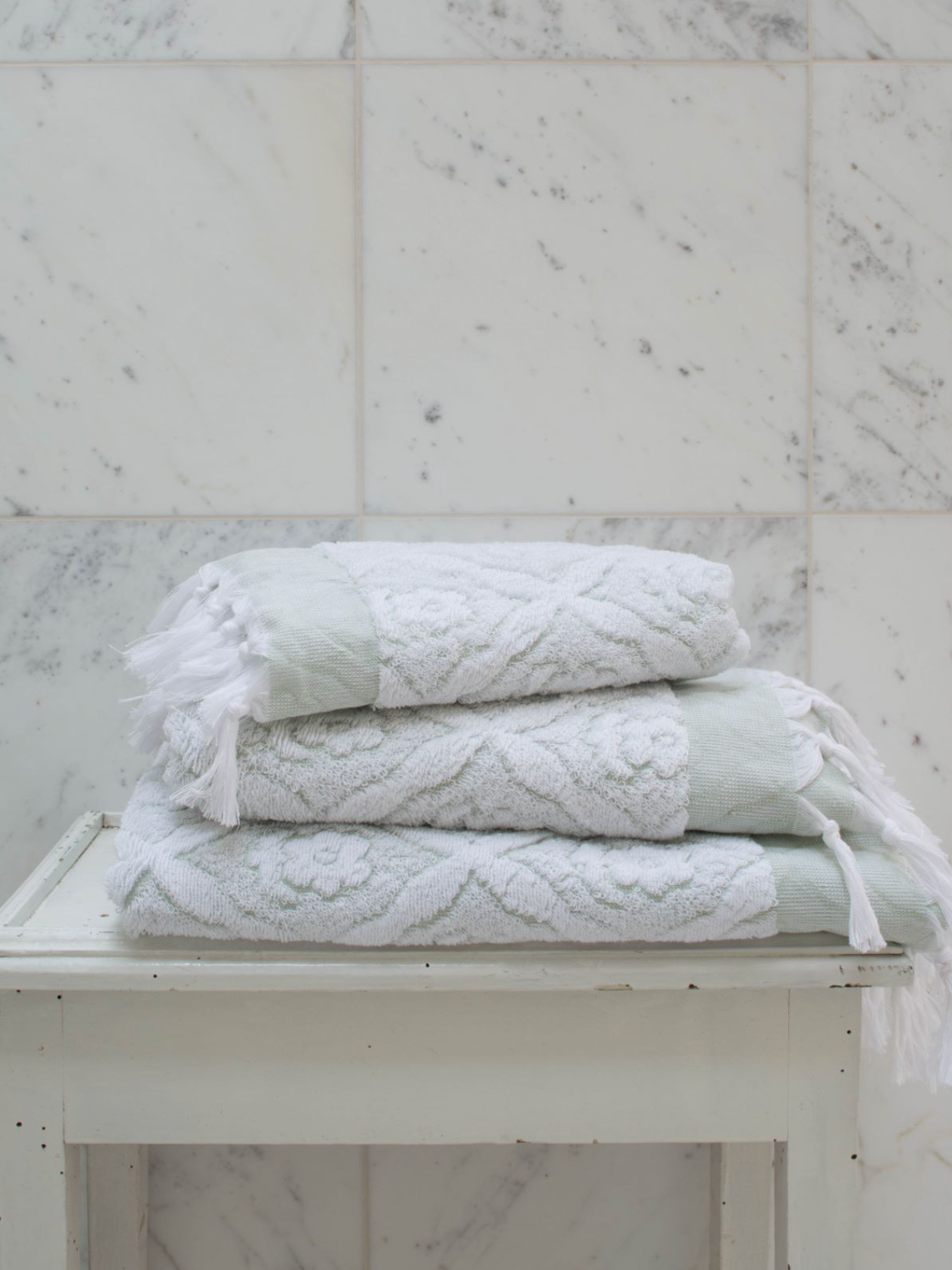 Green DORA hand towel, 100x50 cm, showing soft fabric and fresh color, ideal for bathroom or beach use