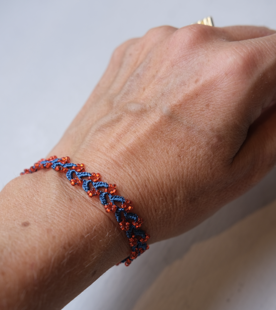 Kniplet armbånd med glasperler • Blåt med orange perler